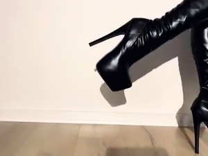 Merciless foot goddess with long legs poses in black boots