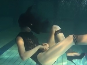 Alluring European teen with long hair swimming underwater