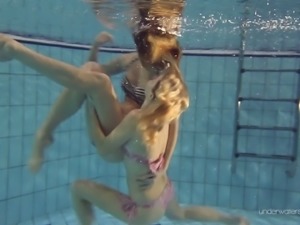 Two white young sexy girls dive in the pool and undress on cam