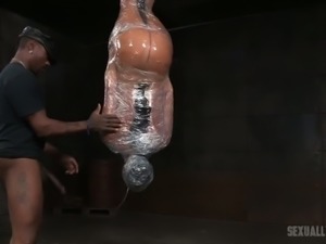 Brunette poor girl wrapped in plastic and suspended upside down