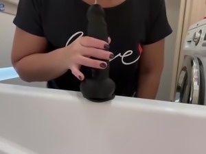 Asian wife fucks black dildo in the bathroom while husband watches TV