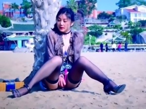 Asian cutie in stockings gets herself off on the beach